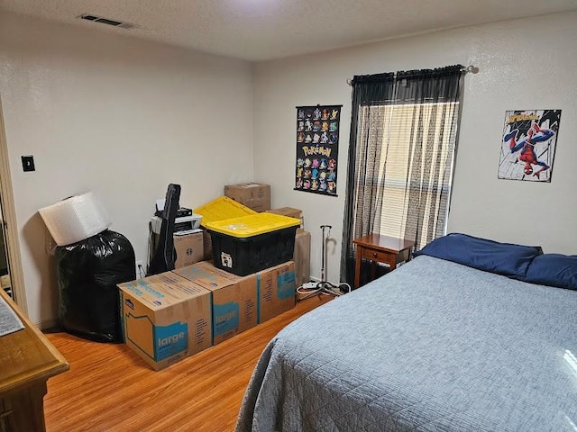 bedroom with hardwood / wood-style flooring and a textured ceiling