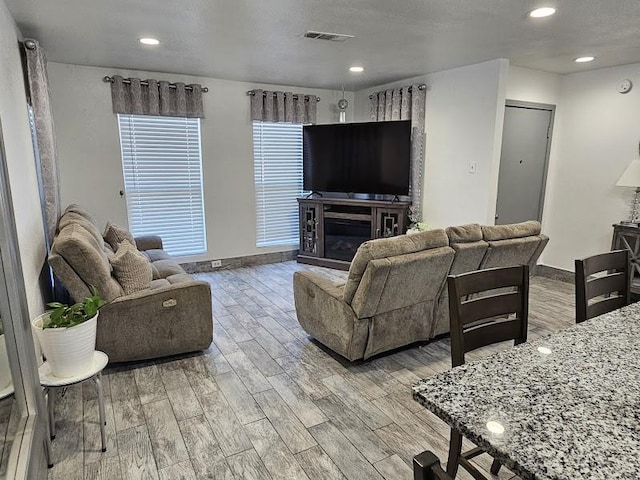 living room with light hardwood / wood-style flooring and a textured ceiling