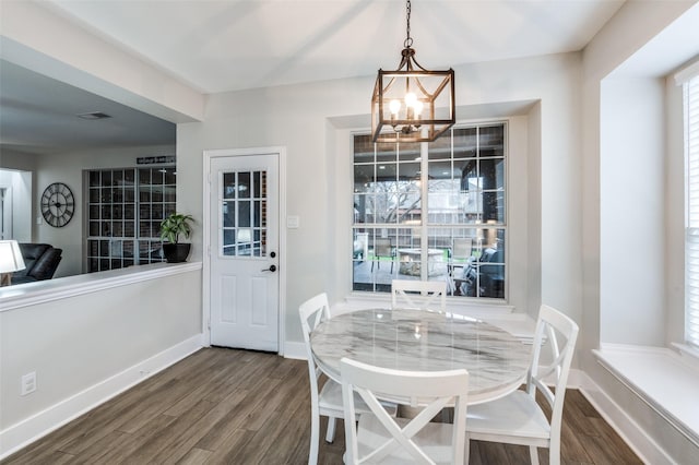 dining space with a chandelier and dark hardwood / wood-style flooring