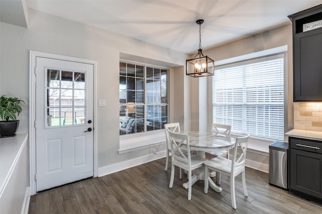 dining space with hardwood / wood-style floors and a notable chandelier