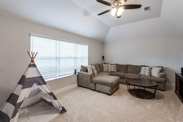 carpeted living room with ceiling fan and vaulted ceiling