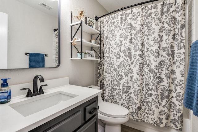 bathroom featuring vanity, curtained shower, and toilet