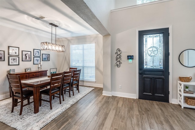 foyer entrance with crown molding, plenty of natural light, and hardwood / wood-style flooring