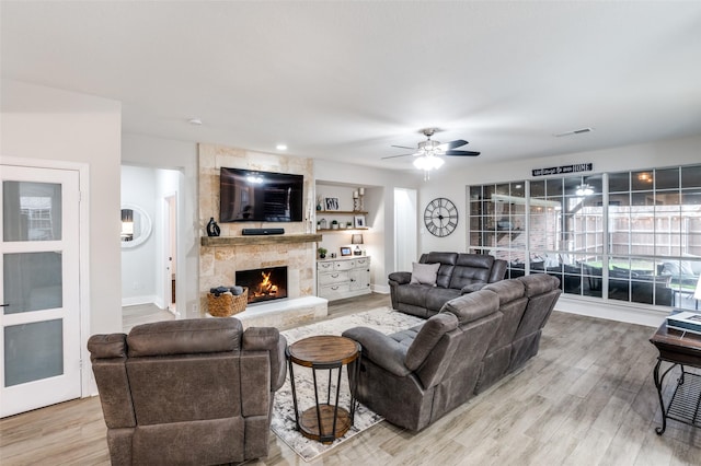 living room with hardwood / wood-style flooring, ceiling fan, and a fireplace