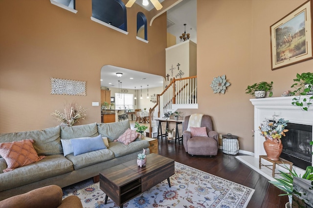 living room with a high ceiling and dark wood-type flooring