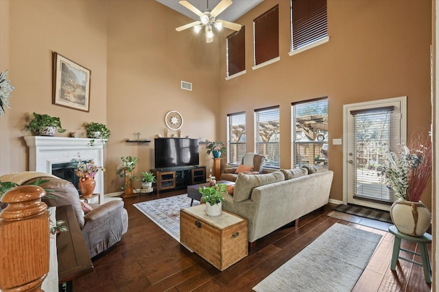 living room featuring ceiling fan and dark hardwood / wood-style flooring