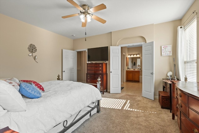 carpeted bedroom with connected bathroom and ceiling fan