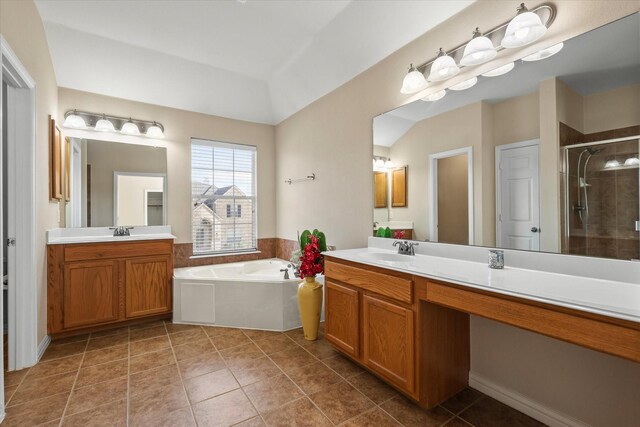 bathroom featuring independent shower and bath, vanity, vaulted ceiling, and tile patterned flooring