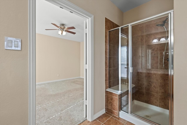 bathroom featuring tile patterned flooring, a shower with shower door, and ceiling fan