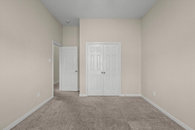 unfurnished bedroom featuring a closet and carpet flooring