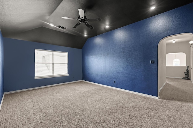 carpeted spare room with ceiling fan, lofted ceiling, and a textured ceiling