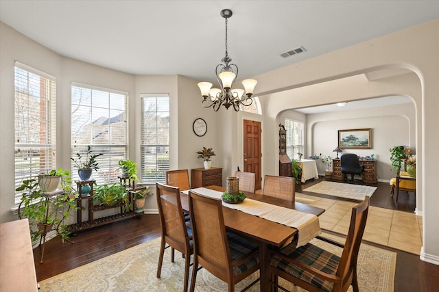 dining space with hardwood / wood-style flooring and a notable chandelier