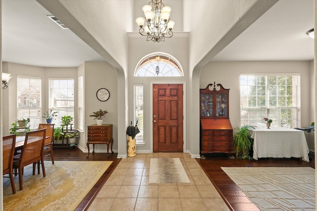 entryway with tile patterned floors and an inviting chandelier