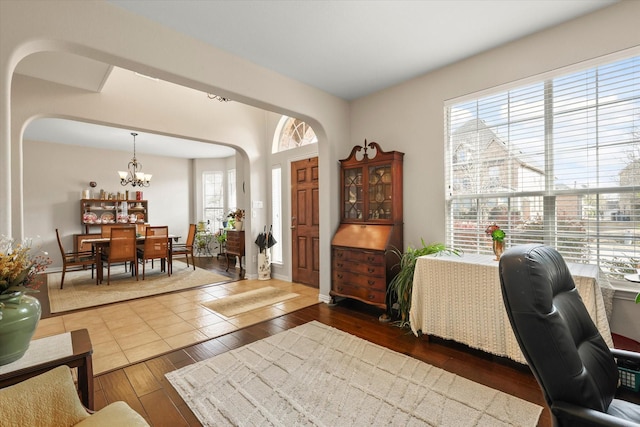 home office featuring dark hardwood / wood-style flooring and a notable chandelier