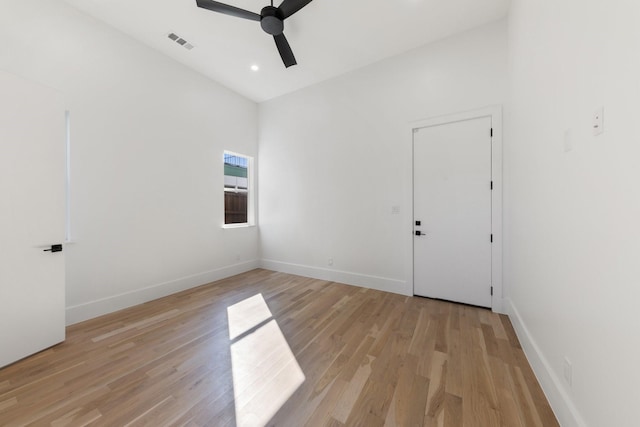 empty room with ceiling fan and light hardwood / wood-style flooring