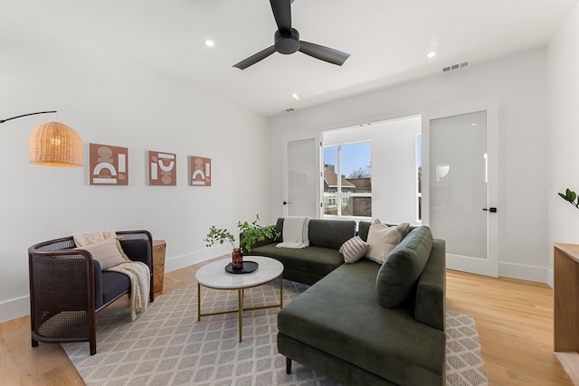 living room with light hardwood / wood-style floors and ceiling fan