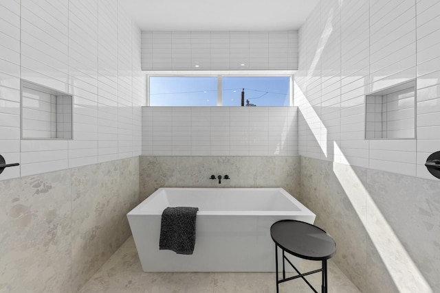 bathroom with tile walls and a bath