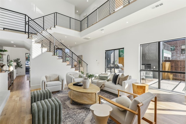 living room featuring hardwood / wood-style flooring, a wealth of natural light, and a towering ceiling