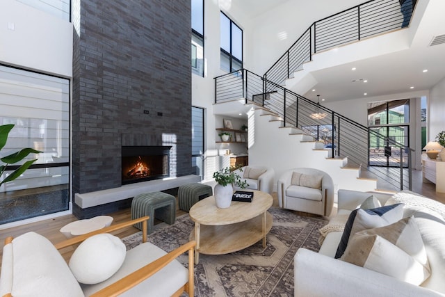 living room featuring a high ceiling, hardwood / wood-style floors, and a fireplace