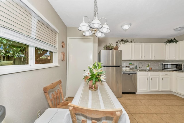 dining room featuring light tile patterned flooring, sink, and a notable chandelier