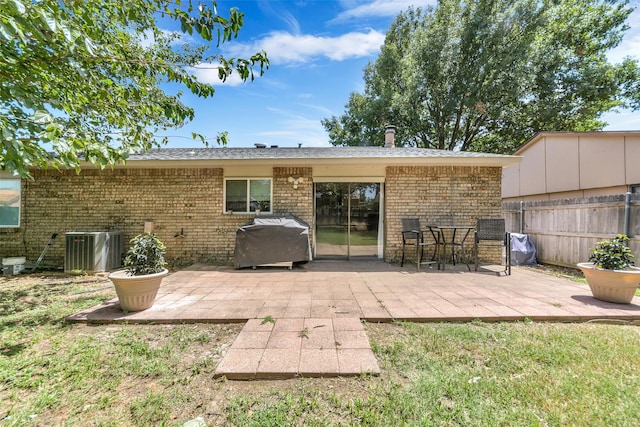 back of property featuring a patio area, central air condition unit, and a lawn