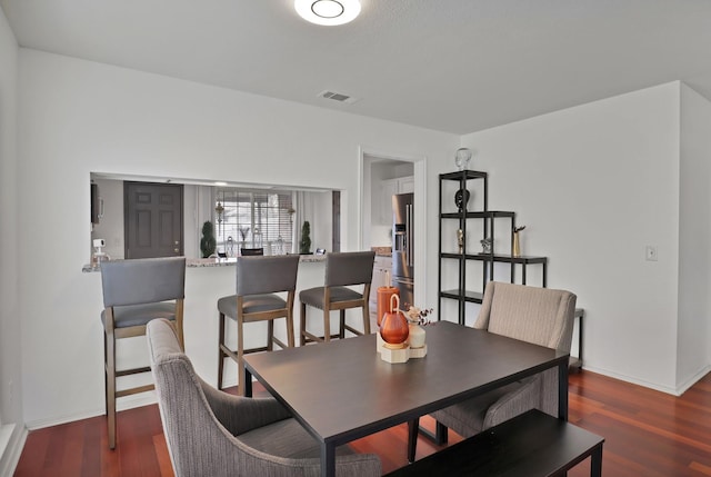 dining area featuring baseboards, visible vents, and dark wood finished floors