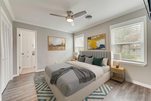 bedroom featuring crown molding, ceiling fan, connected bathroom, light hardwood / wood-style floors, and a closet