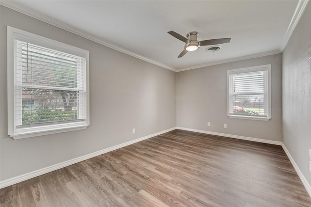 empty room with ornamental molding, hardwood / wood-style floors, and ceiling fan