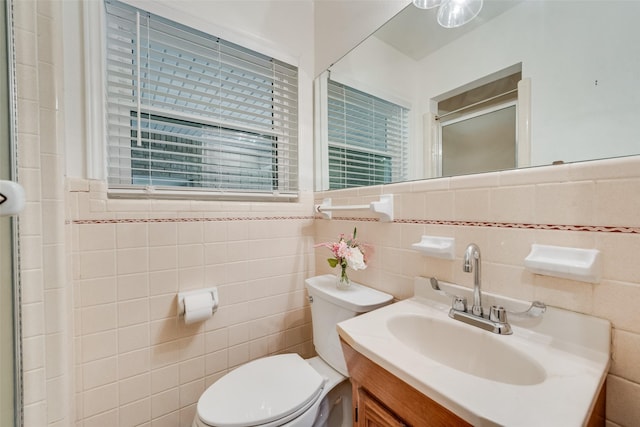 bathroom featuring vanity, tile walls, toilet, and walk in shower