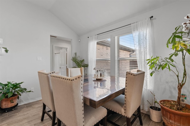 dining space featuring light hardwood / wood-style flooring and vaulted ceiling