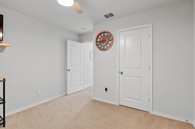 unfurnished bedroom with light carpet and ceiling fan