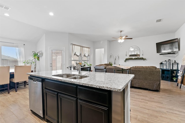 kitchen with dishwasher, sink, a wealth of natural light, and a kitchen island with sink