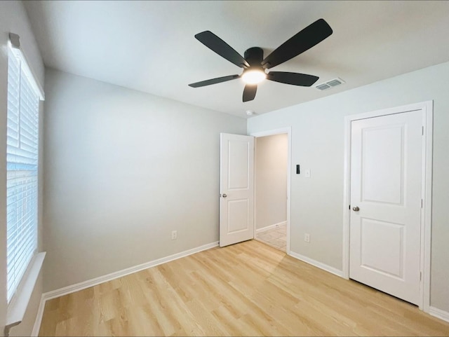 unfurnished bedroom featuring multiple windows, light hardwood / wood-style flooring, and ceiling fan