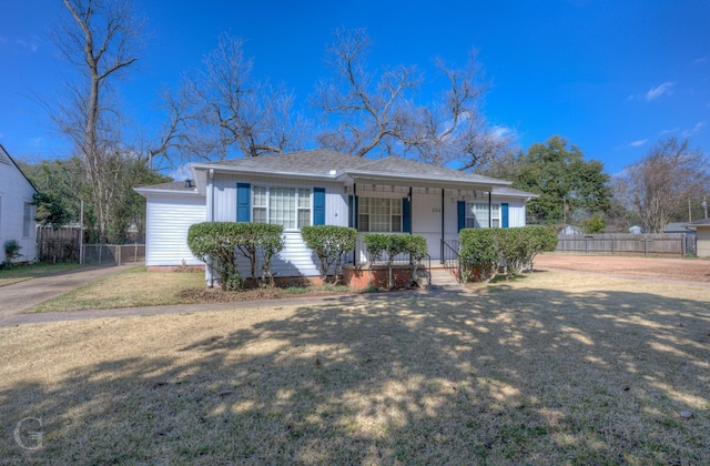 ranch-style house featuring covered porch and a front lawn