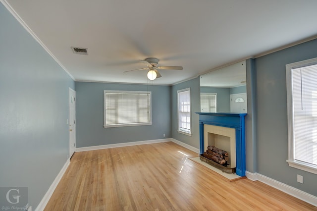 unfurnished living room with crown molding, ceiling fan, and light wood-type flooring