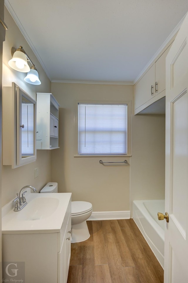 bathroom with hardwood / wood-style flooring, vanity, a bath, ornamental molding, and toilet