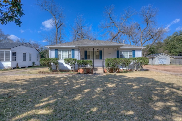 ranch-style house featuring an outdoor structure, a front lawn, and covered porch