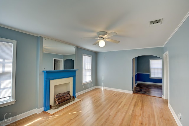 unfurnished living room featuring crown molding, ceiling fan, a fireplace, and hardwood / wood-style floors