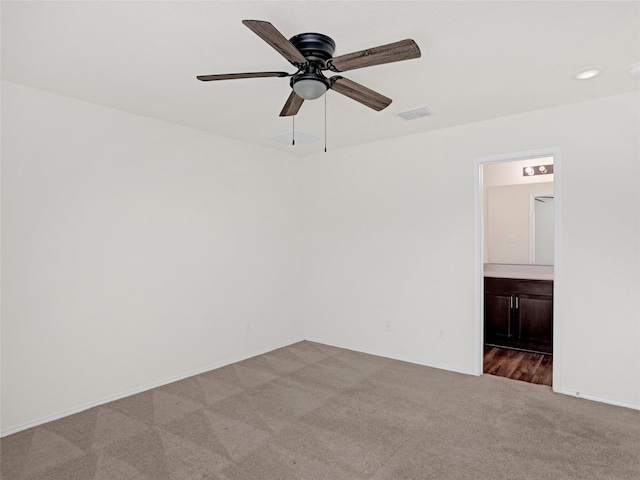 spare room with ceiling fan and light colored carpet