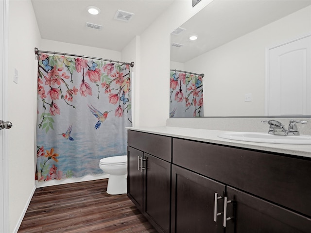 full bathroom featuring vanity, hardwood / wood-style floors, shower / bath combo, and toilet