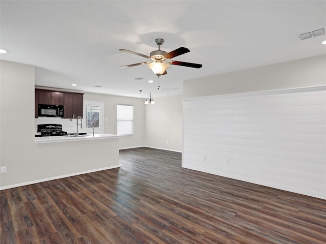 unfurnished living room with dark wood-type flooring, ceiling fan, and sink