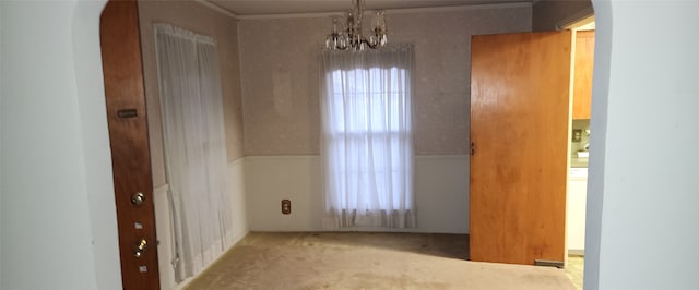 spare room with light carpet and a chandelier