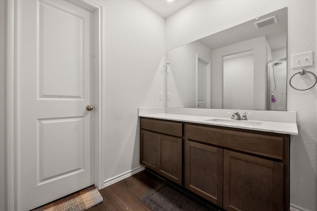 bathroom featuring vanity, wood-type flooring, and a shower