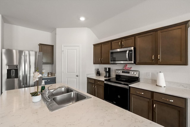 kitchen featuring sink, stainless steel appliances, dark brown cabinetry, light stone counters, and vaulted ceiling