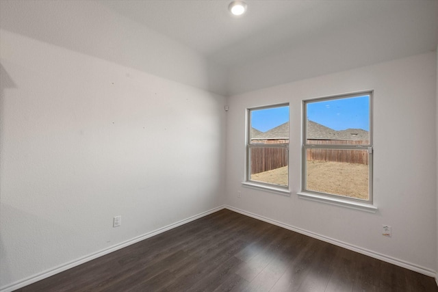 empty room featuring dark hardwood / wood-style floors and vaulted ceiling