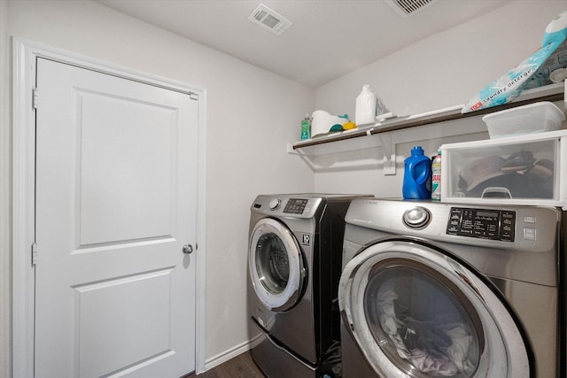 washroom with washing machine and dryer and dark hardwood / wood-style floors