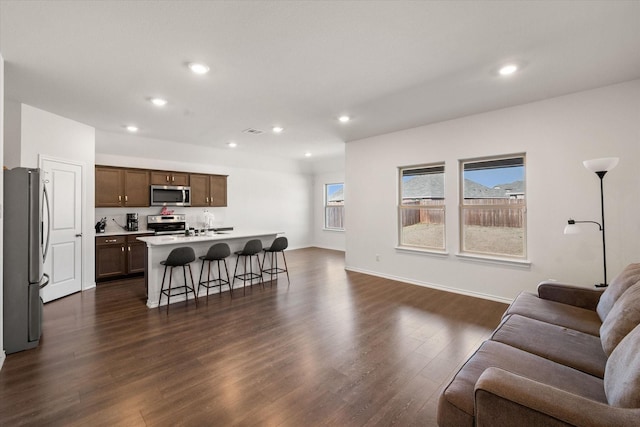 living room with plenty of natural light and dark wood-type flooring