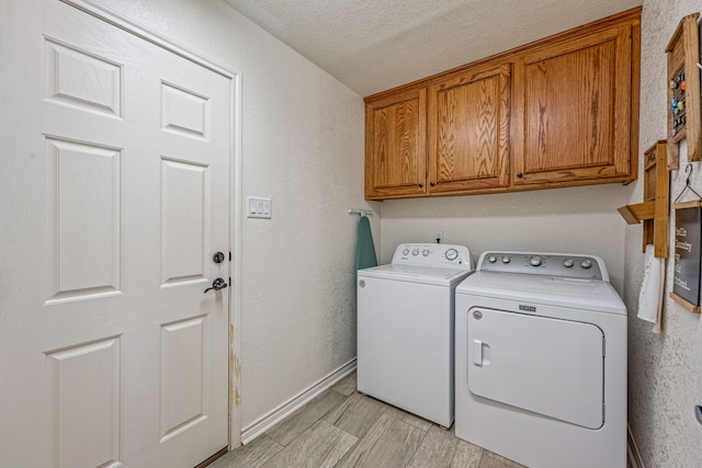 laundry room with cabinets, independent washer and dryer, and a textured ceiling