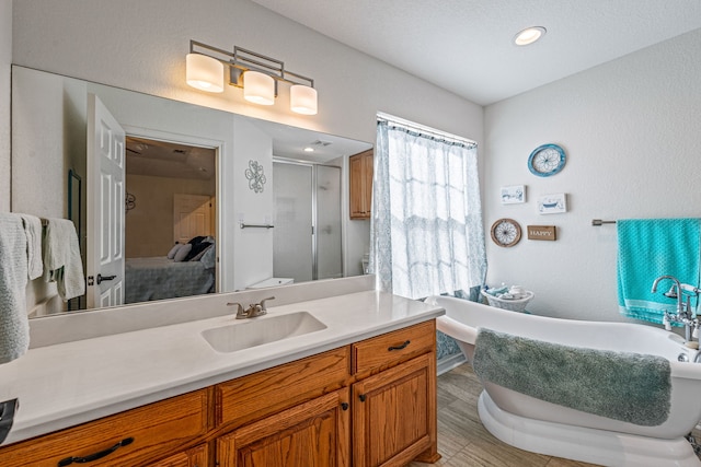 bathroom featuring vanity, wood-type flooring, and shower with separate bathtub