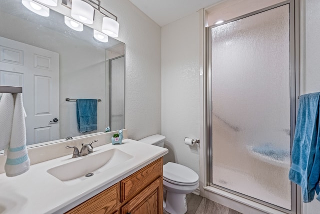 bathroom with vanity, an enclosed shower, hardwood / wood-style flooring, and toilet